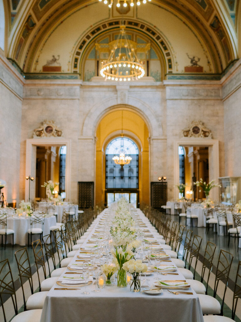 Luxury wedding reception tablescape with layered linens, florals, and candlelight